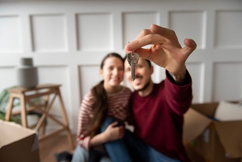 Duas pessoas com uma chave na mão, indicando a conquista de uma nova casa.